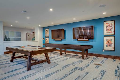 a games room with two pool tables and a television