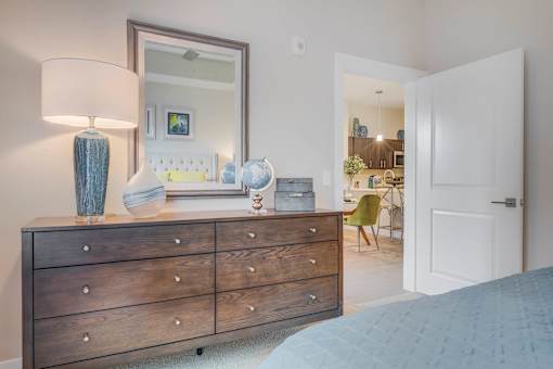 a bedroom with a dresser and a mirror