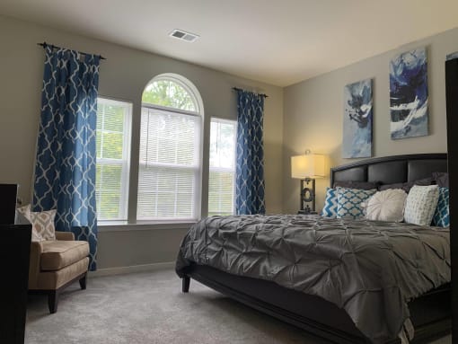 a bedroom with a bed and windows with curtains