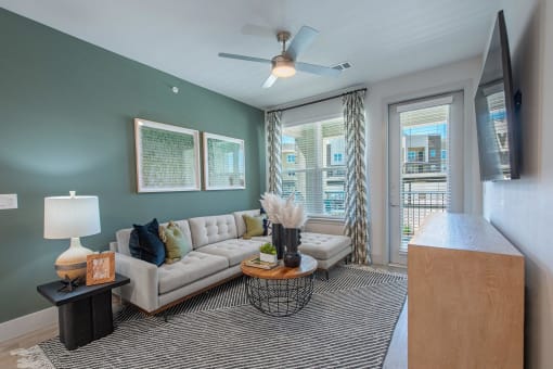 a living room with a couch and a ceiling fan