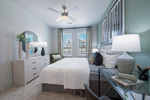 a bedroom with a large bed and a ceiling fan