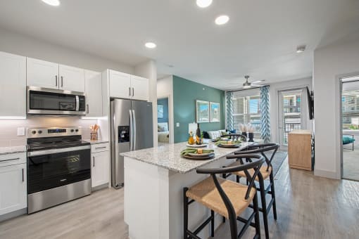 a kitchen with white cabinets and a table with stools