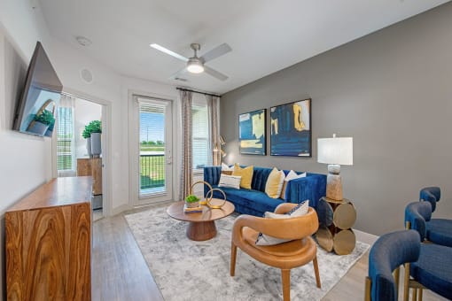 a living room with a blue couch and a ceiling fan