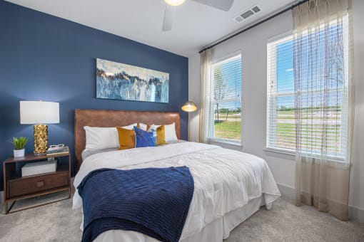 a bedroom with a bed and two windows