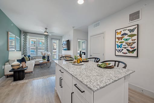 an open kitchen and living room with a large counter top