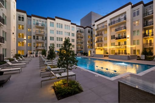 an apartment building with a swimming pool at night