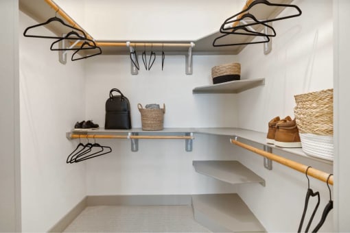 a walk in closet with shelves and hooks