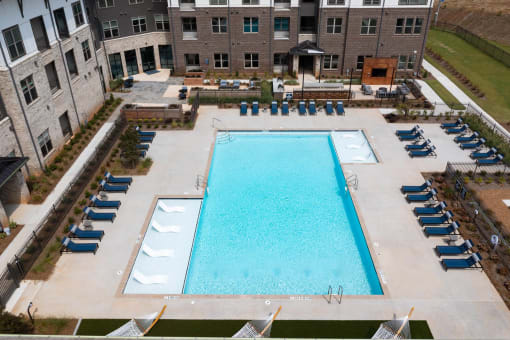 an aerial view of a swimming pool in front of an apartment building