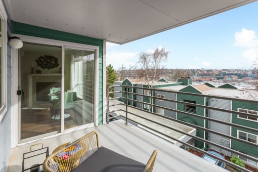 a balcony with a table and chairs and a view of a city