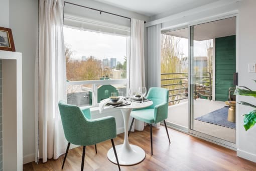 a living room with a table and chairs and a balcony