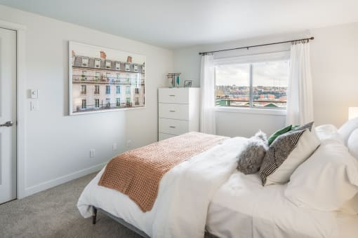 a bedroom with a bed and a window and a dresser