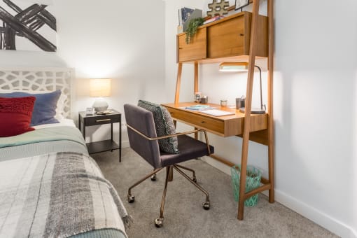 a bedroom with a bed and a desk with a computer