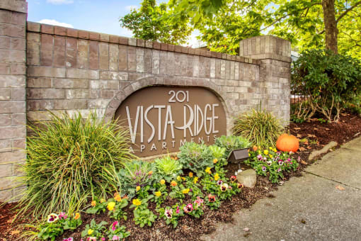 a sign apartments in front of a garden