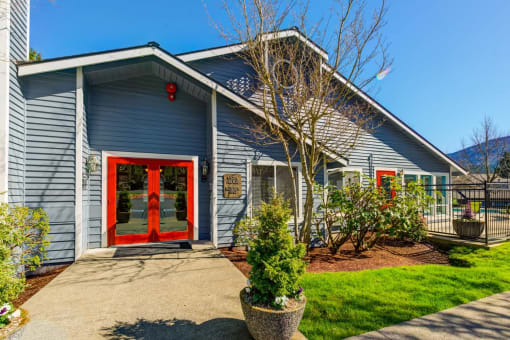 the front of a blue house with a red door