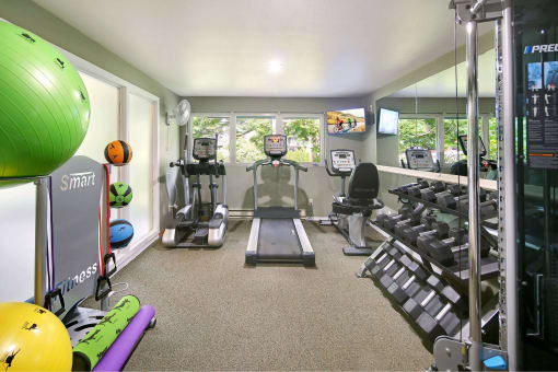 a gym with cardio equipment and a window view of the outdoors