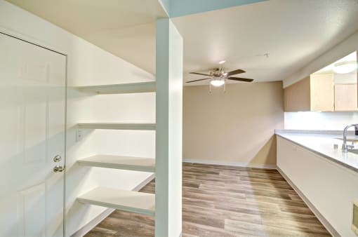 a kitchen with white cabinets and a ceiling fan