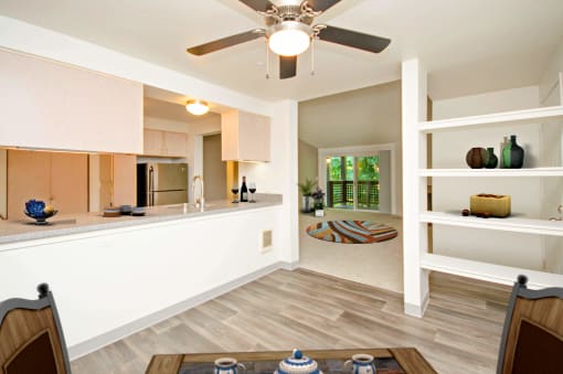 a kitchen and living room with a ceiling fan