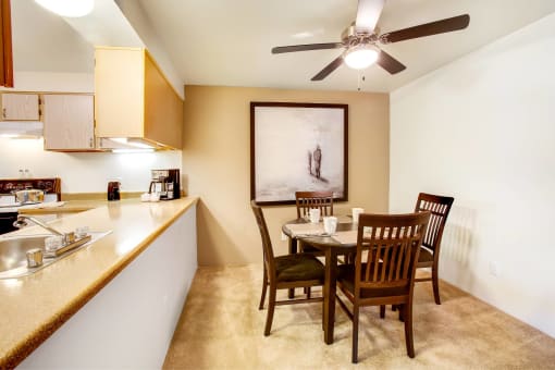 a dining room and kitchen with a table and chairs