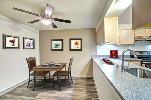 a dining room table with chairs next to a kitchen