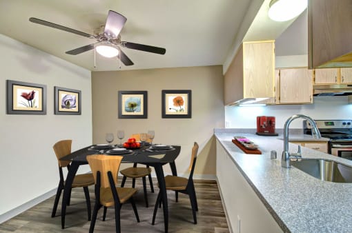 a dining room table with chairs next to a kitchen