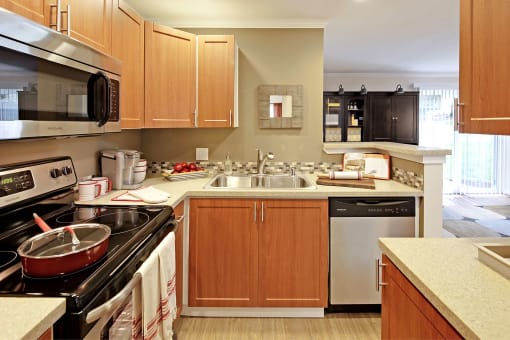 a large kitchen with wooden cabinets and a sink