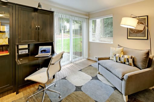 a living room with a couch and a chair and a desk