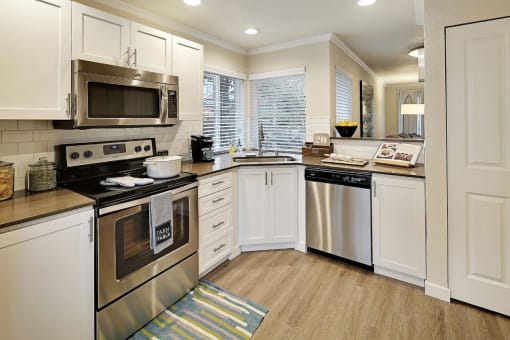 a kitchen with stainless steel appliances and white cabinets