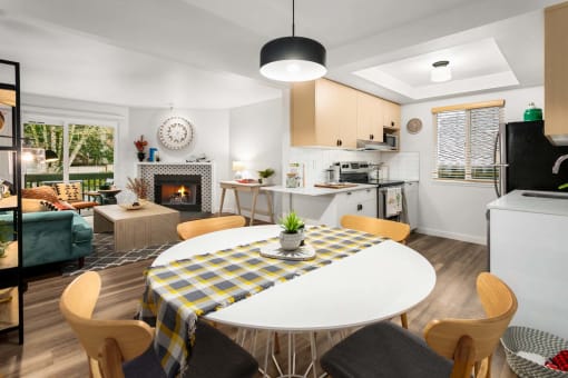 a living room and kitchen with a table and a fireplace