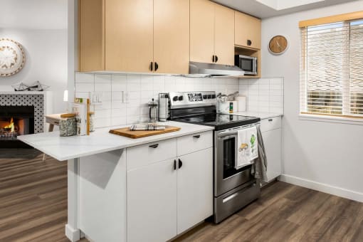 a kitchen with white cabinets and a stove and a fireplace