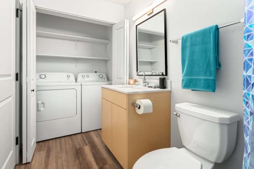 a bathroom with a toilet and a sink and a washing machine