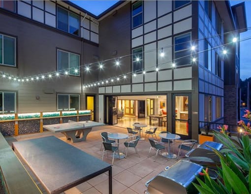 a patio with tables and chairs outside of a building
