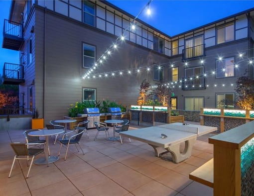 an outdoor patio with tables and chairs at night