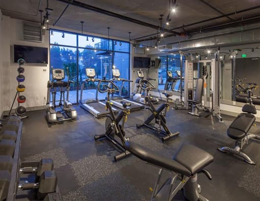 a gym with exercise equipment and a large window