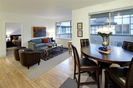 a living room and dining room with a table and chairs
