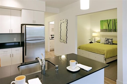 a kitchen and a bedroom with a sink and a refrigerator
