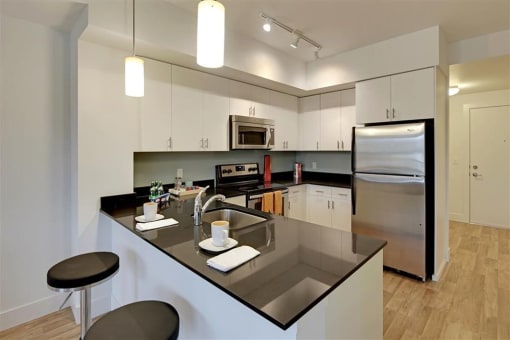 a kitchen with an island and a stainless steel refrigerator