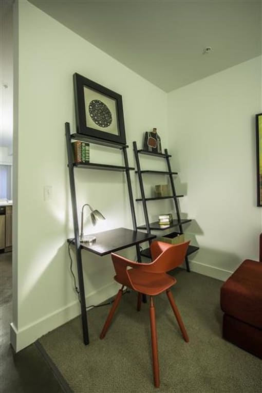 a room with a desk and a chair and a shelf