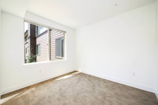 a living room with a large window and a carpet