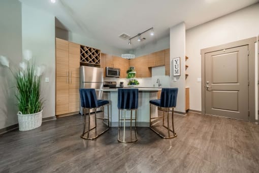 a kitchen with a bar with three stools