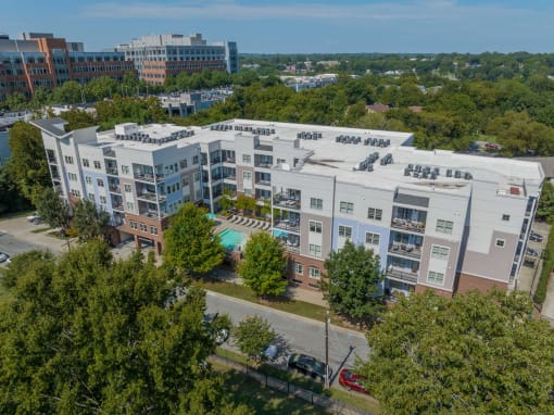 a view of a building from above with a pool and trees
