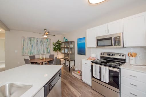 a kitchen with white cabinets and stainless steel appliances
