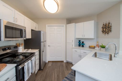 a kitchen with white cabinets and black appliances