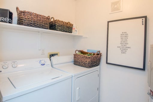 a white washer and dryer in a laundry room with baskets