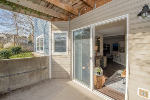 a covered porch with a sliding glass door and a kitchen