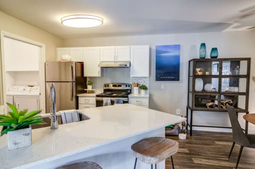 a kitchen with a white counter top and a stainless steel refrigerator