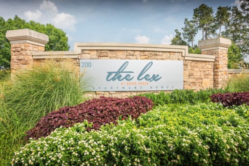 a sign that reads the lee in front of a stone wall
