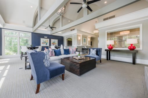 a living room with blue and white furniture and a ceiling fan