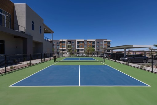 a blue and green tennis court with apartments in the background at Element 12 Apartments, Henderson NV
