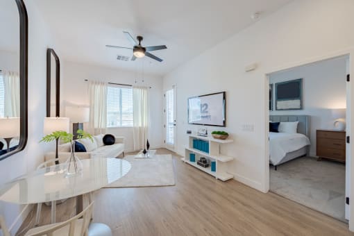 a living room with a reflection of a bedroom in a glass wall at Element 12 Apartments, Henderson NV