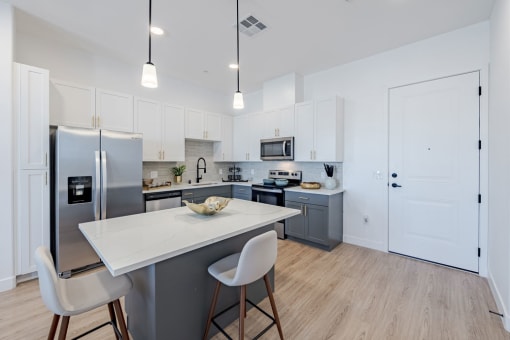 a kitchen with an island and a stainless steel refrigeratorat Element 12 Apartments, Henderson NV